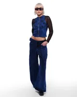 Top azul denim con corte nadador, lavado artesanal y confeccionado en algodón y elastano.