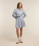 Vestido corto camisero de tricolina de algodón a rayas celestes y blancas, con cuello solapa, abotonado delantero, mangas largas y cintura marcada.