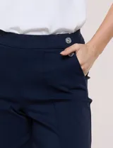Pantalón crop blanco de corte recto con cintura ancha y botones decorativos laterales. Cuenta con bolsillos y pinzas frontales.