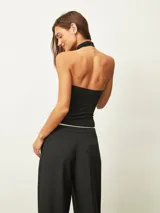 Top negro de cuello alto estilo halter, confeccionado en tejido ajustado al cuerpo, sin mangas.