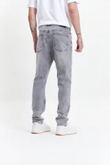 Pantalón jean gris de corte slim, tiro medio y con presillas para cinturón.