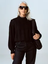 Sweater negro de punto con cuello redondo y mangas largas abullonadas con puños acanalados.