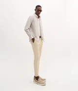 Pantalón slim de sarga color beige para hombre, con cintura con trabillas, cierre tradicional y bolsillos laterales y traseros.
