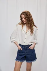 Short de jean blanco de tiro medio con silueta relajada y detalle de ruedo desflecado con flecos.