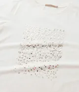 Remera de algodón color blanco con cuello redondo y mangas cortas. Presenta un estampado de lentejuelas con efecto de lluvia en el frente.