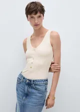 Body de tejido de punto en color beige, con cuello en pico y tirantes anchos. Presenta una hilera de botones decorativos en el frente y un diseño entallado al cuerpo.