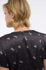 Top negro con estampado animal print en tonos beige y marrón, escote en V y lazo de ajuste en el centro.