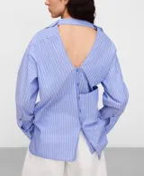 Camisa de algodón con diseño desestructurado a rayas celestes y blancas, cuello camisero, manga larga y cierre frontal de botones.