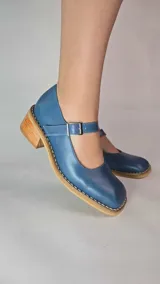 Guillerminas de cuero legítimo color azul, con puntera cuadrada, taco bajo de madera y tira con hebilla ajustable en el empeine.