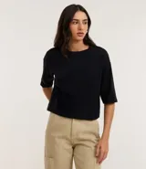 Remera cropped de algodón, color negro, con cuello redondo y mangas cortas.