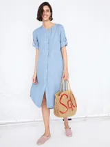 Vestido celeste de lino con escote en V y cierre frontal con botones.