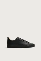 Zapatillas de cordones de estilo minimalista, color negro, con diseño liso, horma redonda, forro interior en tono contrastante y suela de goma texturizada.