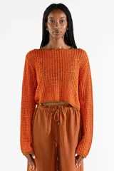 Sweater crop de manga larga tejido con hilos metalizados que aportan brillo, con escote bote amplio.