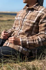 Camisa leñadora marrón a cuadros con forro de corderito sintético, cierre con botones y dos bolsillos frontales con tapa.