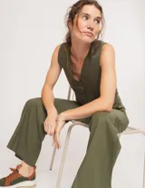 Pantalón negro de lino, tiro alto, corte palazo, con elástico en la pretina trasera, cierre delantero y broche interno. Tiene bolsillos laterales, dobladillo invisible y tajos a los costados.