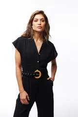 Mono negro con cuello camisero, mangas cortas, cinturón con hebilla circular de bambú y bolsillos laterales.