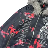 Campera con cierre frontal, confeccionada en poliéster con estampado gráfico tipo camuflado y tipografía. Presenta capucha con borde de piel sintética no removible y ajuste regular.
