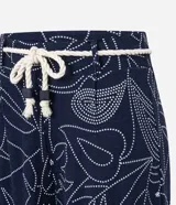 Pantalón recto de viscosa color azul marino con estampado lineal de follaje en blanco. Posee talle alto con trabillas y se ajusta con un cinturón de cuerda blanco. El pantalón es de corte cropped.