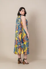 Vestido midi de satén estampado con motivos étnicos en tonos amarillo, azul y rojo. Diseño suelto, plisado y con cuello halter.