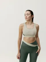 Top deportivo de sujeción media color verde militar con banda inferior color beige. Diseño reversible con tirantes anchos y espalda cruzada.