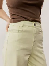Pantalón de jean verde lima, de corte recto y tiro alto, con bolsillos traseros y etiqueta de cuero con logo en la parte posterior.