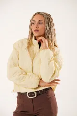 Campera color manteca con diseño acolchado de flores, cuello alto, cierre frontal con cremallera y bolsillos laterales.