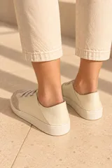 Championes de cuero vacuno color celeste con puntera de gamuza marrón, suela de goma y cordones elásticos.