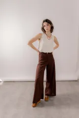Pantalón wide leg de lino color marrón, de tiro alto con bolsillos traseros y frontales, cierre frontal con botón y bragueta.