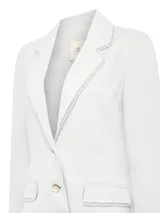 Blazer de lino orgánico color blanco, con corte recto, cuello sastre y cierre frontal de dos botones. Presenta detalles de costura calada en el borde del cuello y en las tapas de los bolsillos frontales.