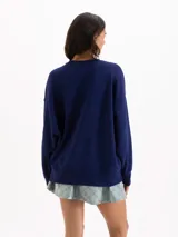 Buzo azul marino de corte oversize y cuello redondo, con diseño gráfico estampado de una flor y una abeja en el frente.