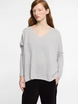 Sweater gris de tejido de punto con escote en V y tejido con brillo.