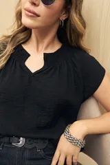 Blusa color rosado con textura arrugada, escote en V con detalle de fruncido y mangas cortas.