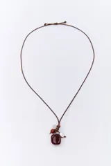 Colgante con cordón marrón ajustable y dije de piedra beige con manchas negras, cuentas de madera marrón, piedra blanca opaca y dije plateado en forma de pluma.