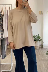Remera beige de corte oversize con cuello redondo y mangas largas. Tejido con textura acanalada. Hecho en Uruguay.