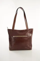 Cartera tipo tote de cuero vacuno negro con doble asa de hombro, panel superior liso y bolsillo exterior frontal con textura símil cocodrilo y costuras visibles en contraste.