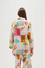 Camisa de algodón con estampado de motivos tropicales, corte holgado, con botones y cuello camisero.