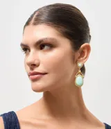 Aros colgantes de estilo vintage con base circular texturizada y dije ovalado, ambos con piedra central en tono turquesa. Estructura de metal con acabado martillado.