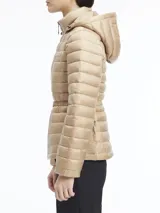 Campera color beige de nailon reciclado, con cuello alto, capucha con cordón ajustable, cierre de cremallera frontal, bolsillos laterales con cremallera, cinturón con hebilla metálica y logo de Calvin Klein en el pecho.