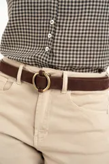 Cinto marrón de gamuza con hebilla circular dorada.