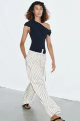 Body azul marino de escote asimétrico con un hombro descubierto, detalle de frunces en el busto y cierre de botones a presión en la parte inferior.