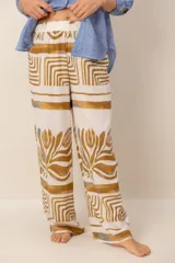 Pantalón holgado de lino blanco con estampado en tonos ocre y azul, de corte recto y cintura elástica fruncida.