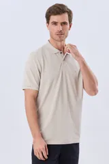 Remera polo de piqué de algodón color azul, de manga corta, con cuello camisero, cierre frontal de dos botones y pequeño logo bordado en el pecho.