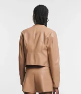 Campera básica de cuero sintético (PU) color marrón oscuro, con cuello redondo, cierre frontal y recortes decorativos. Cuenta con mangas largas y bolsillos con cierre.