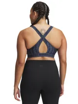 Top deportivo Under Armour con estampado abstracto en tonos de azul y gris. Cuenta con breteles anchos cruzados en la espalda y banda elástica con el logo de la marca.