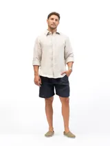 Camisa de manga larga color beige confeccionada en lino, con cuello clásico y cierre frontal con botones.