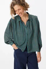 Camisa de manga larga con diseño de rayas verticales en tonos verde, azul y marrón. Presenta cuello clásico, cierre frontal con botones y mangas abullonadas con puños ajustados.