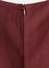 Vestido midi color bordó con cuello redondo, sin mangas y corte recto, con detalle de nudo y lazo ajustable en la cintura.