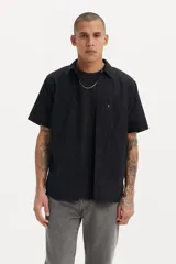 Camisa negra de manga corta con cuello clásico, cierre frontal con botones y bolsillo en el pecho.