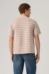Remera Levi's de corte holgado con diseño de rayas horizontales en tonos beige y rosado. Presenta cuello redondo y un pequeño logo bordado en el pecho.