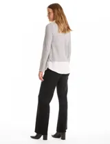 Buzo combinado de hilado fino color gris, con cuello en V y mangas largas. Presenta una pieza inferior y cuello tipo solapa en tela blanca que simula una camisa debajo.